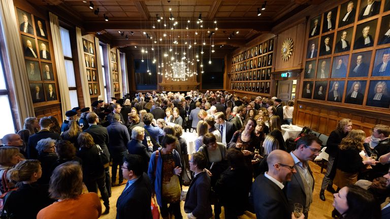 Gasten in de zaal met hoogleraarsportretten na een oratie in Utrecht